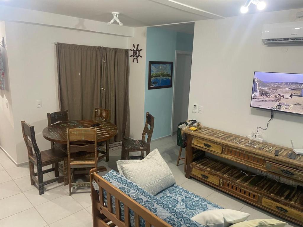 a living room with a couch and a table and a television at Apartamento Itapoá in Itapoa