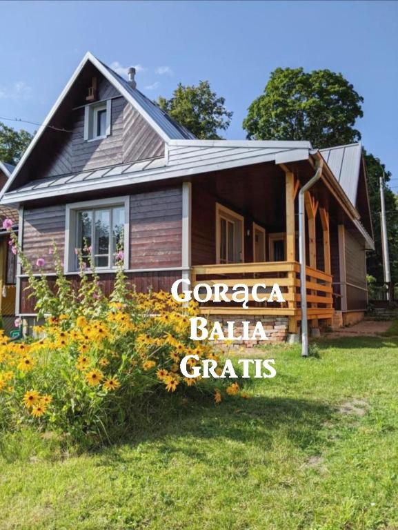 a house with a sign that reads cancer ballarian crafts at Domek pod Jabłonią - z balią in Białowieża