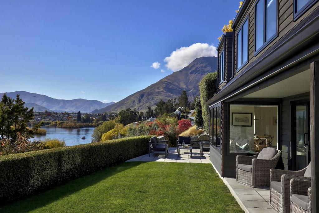 a house with a patio with a view of a river at Perfect on the Peninsula with Lake View and Hot Tub in Frankton Wharf