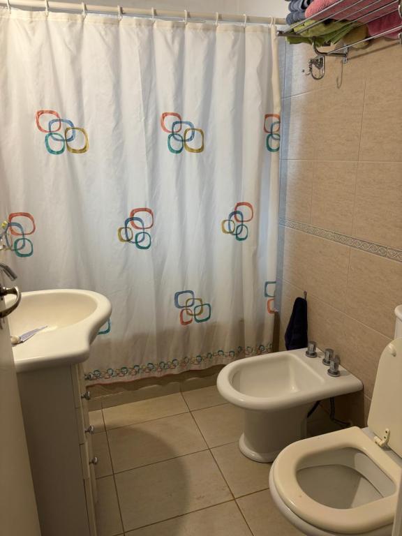 a bathroom with a shower curtain and a toilet and a sink at Amplio 4 ambientes a la calle in Miramar