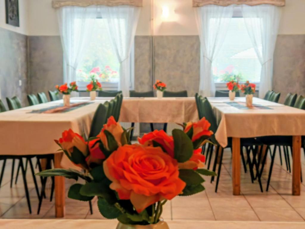 a room with two tables with flowers in a vase at Gostilna The RIVER in Dravograd
