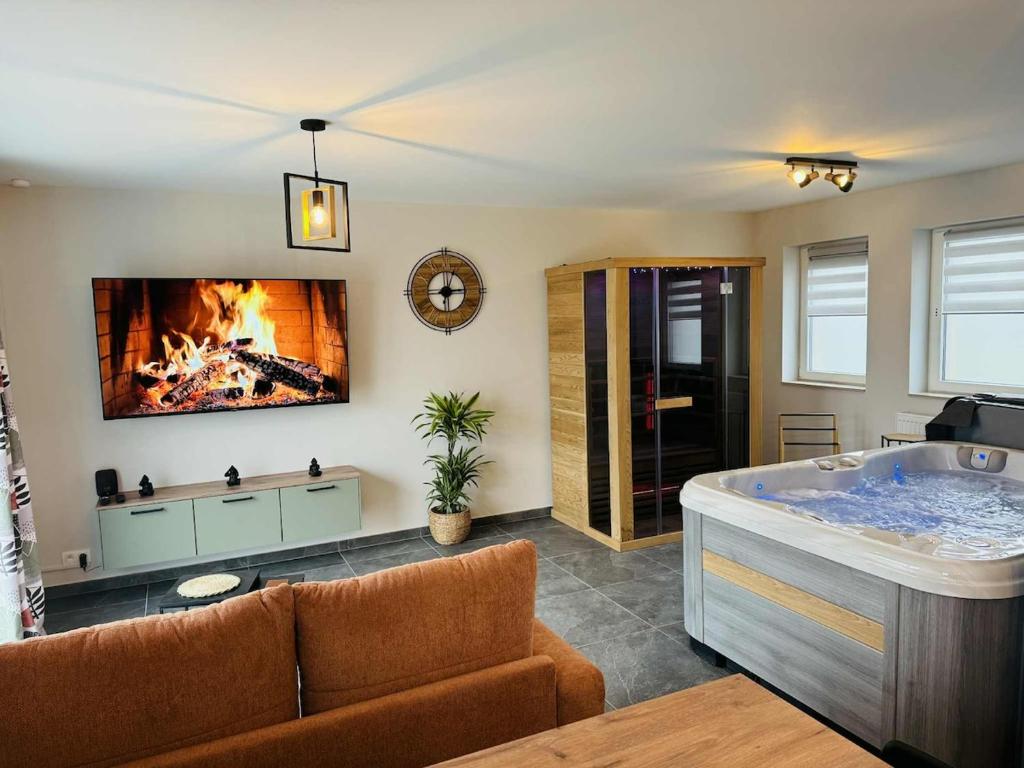 a living room with a tub and a fireplace at Le cocon de pernelle in Couvin