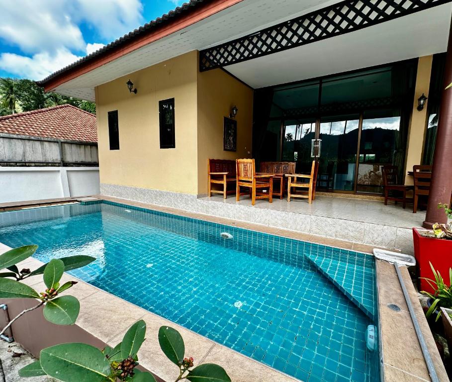 a swimming pool in front of a house at 3 bedroom villa with swimming pool Lamai in Nathon Bay