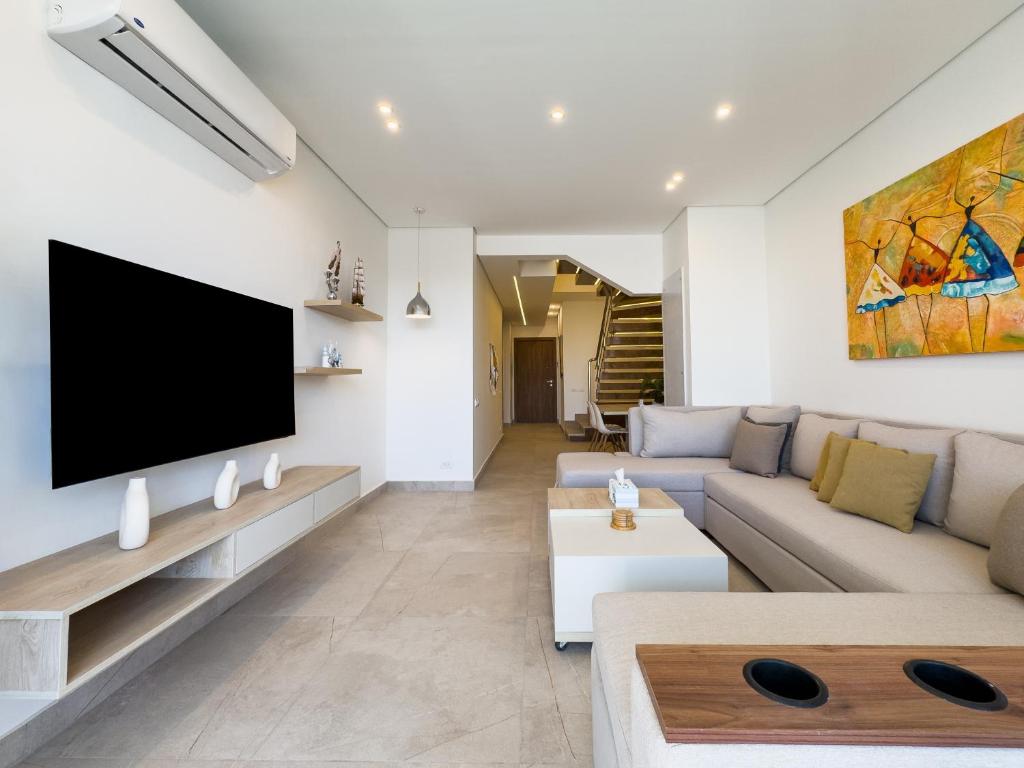 a living room with a couch and a flat screen tv at Poolside Townhome with 2 Masters, a Huge Terrace in El Gouna in Hurghada