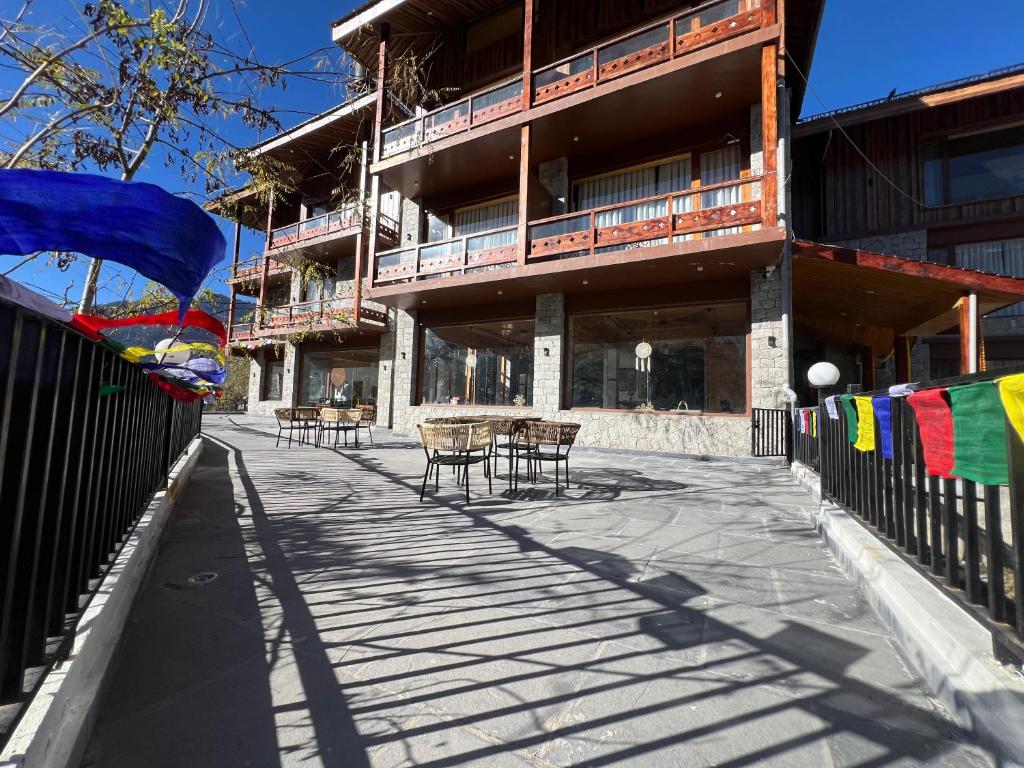 un bâtiment avec des chaises et des tables devant lui dans l'établissement Rigzin House by Meghsparsh Resorts, à Palchān