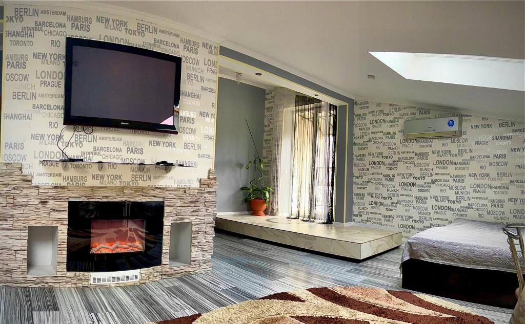ein Wohnzimmer mit einem Kamin und einem TV an der Wand in der Unterkunft Stone City Apartment in Park Zone in Kamjanez-Podilskyj
