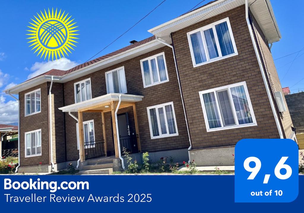 ein braunes Backsteinhaus mit einer gelben Sonne darüber in der Unterkunft Sunrise House in Tscholponata