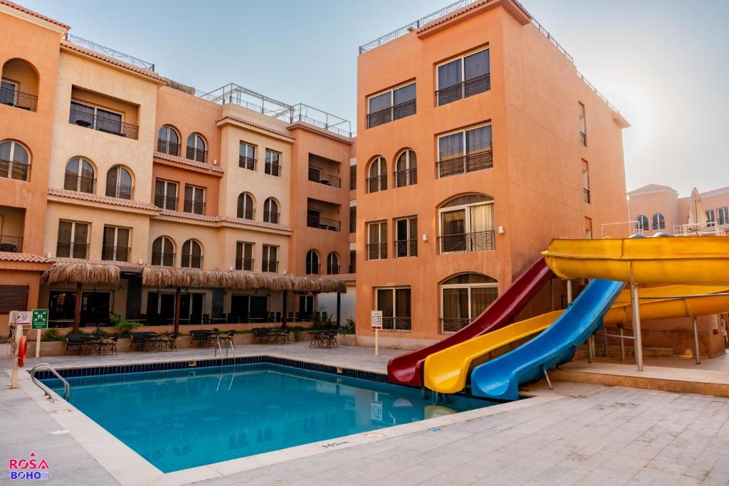 a pool with a slide in front of a building at Rosa Boho Hotel And Aqua Park in Hurghada