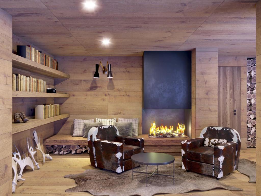 Le Mallet, Courmayeur, Alpine Homesuite في كورمايور: غرفة معيشة مع كرسيين ومدفأة