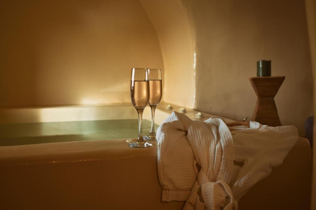 een wijnglas op een tafel met een handdoek bij OIA UNIQUE HOMES by K&K in Oia