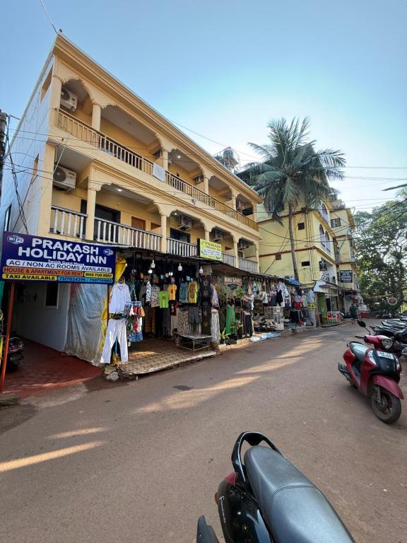a man standing in front of a store on a street at Prakash Holiday Inn in Arambol