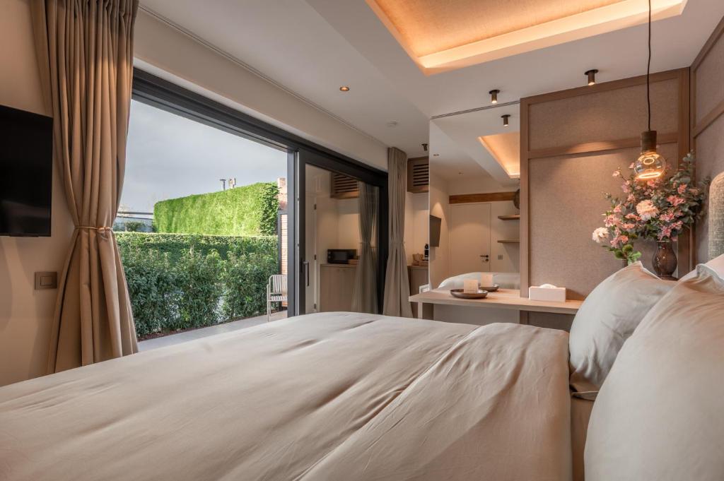 a bedroom with a bed and a large window at Luxe Guestroom free bikes and parking in Bruges