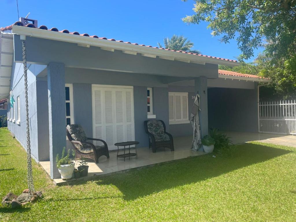 eine Terrasse mit 2 Stühlen und einer Schaukel in der Unterkunft casa no centro proximo ao mar in Xangri-lá