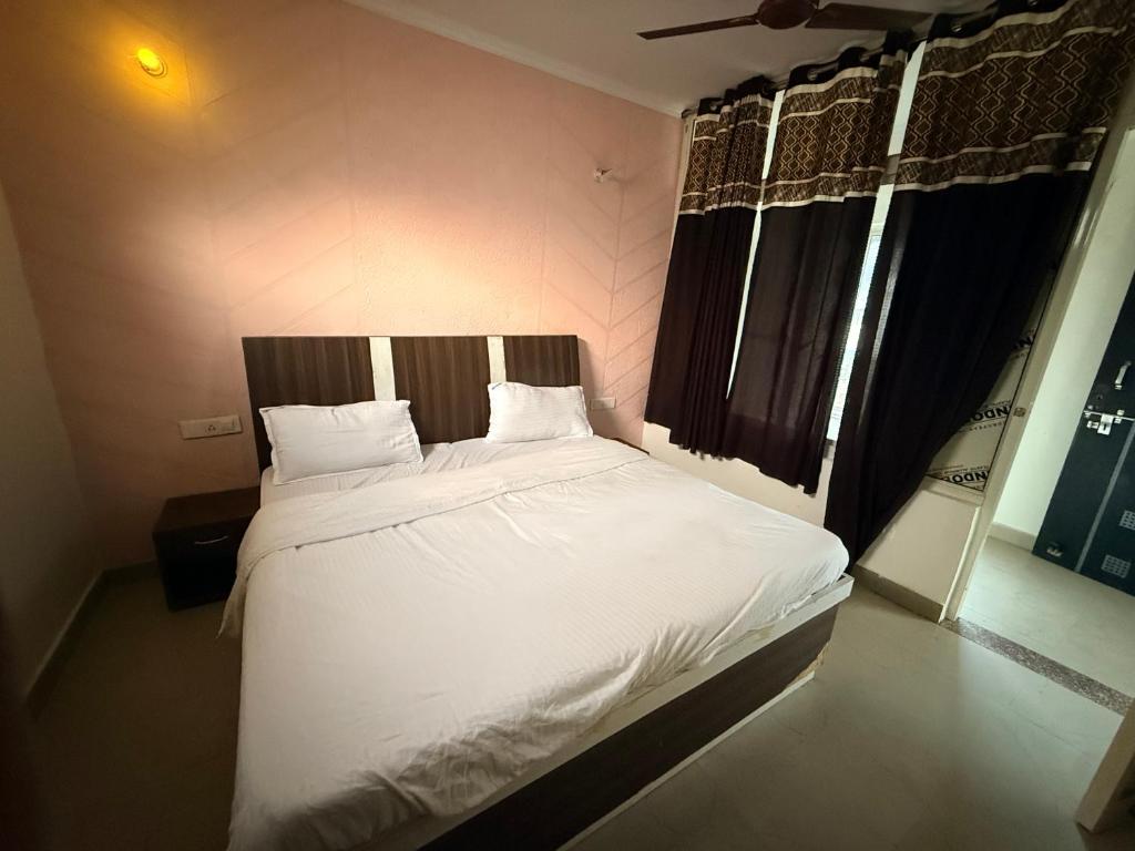 博瓦利Sk inn hotel的卧室里有一张床，床单和枕头都是白色的