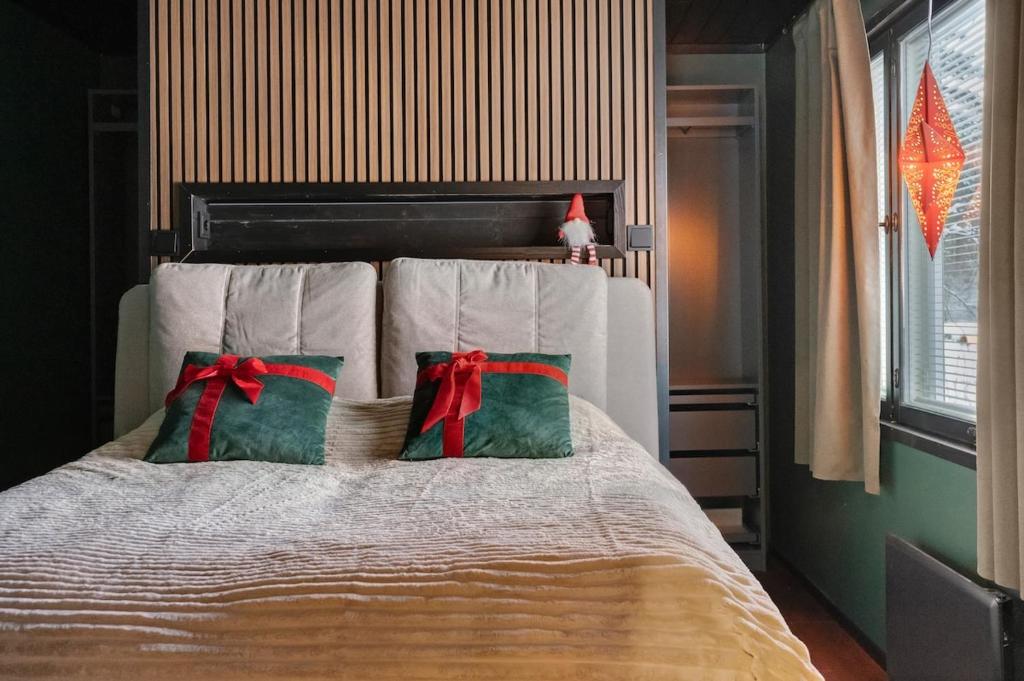 una habitación con una cama con dos almohadas navideñas en Villa Lapland Luxe, Private Sauna, Free Wifi, en Rovaniemi