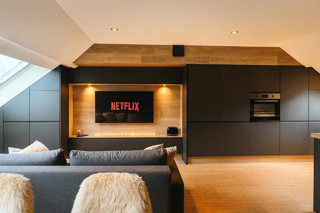 ein Wohnzimmer mit Sofa und Fernseher in der Unterkunft Ma Montagne Chic 2 in La Bresse