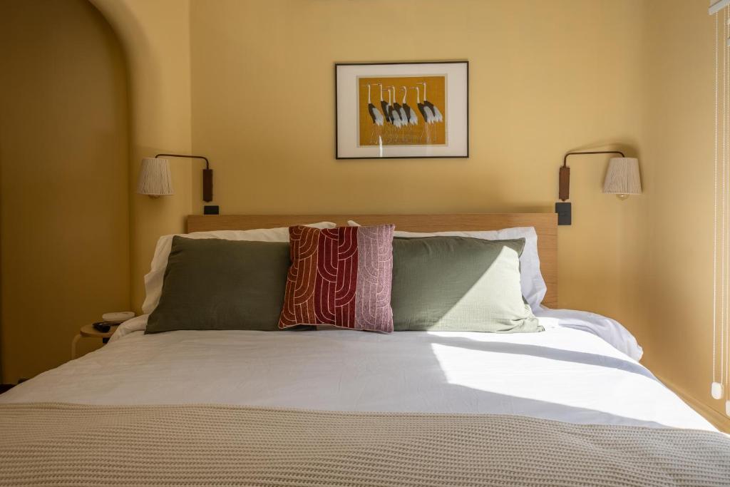 a bed with two pillows on top of it at Apart Hotel Dresden in Santiago