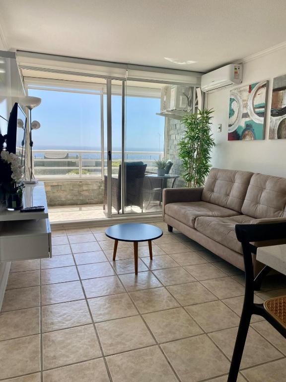 a living room with a couch and a table at Departamento Playa Cochoa, Reñaca in Viña del Mar