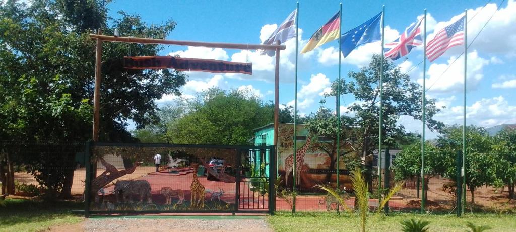 une porte avec des drapeaux devant une aire de jeux dans l'établissement Bush Adventure Guest House, à Kasane