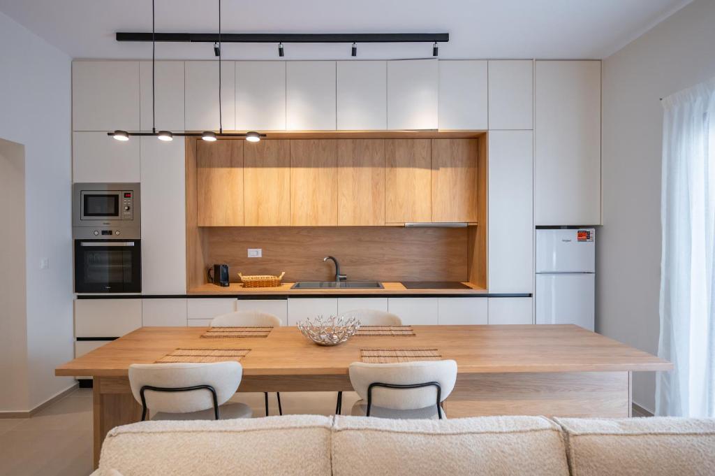 a kitchen and dining room with a wooden table and chairs at Michail Old Harbour Residence in Kos