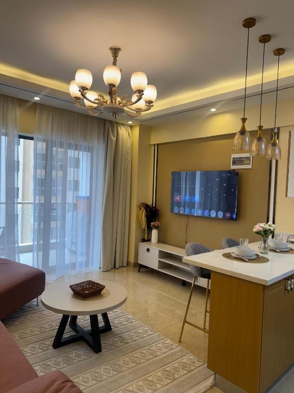 a living room with a kitchen and a living room with a table at Enzi Apartment Block A in Nairobi