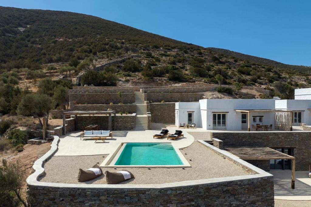 a villa with a swimming pool in front of a mountain at New Project Fos in Platis Yialos Sifnos