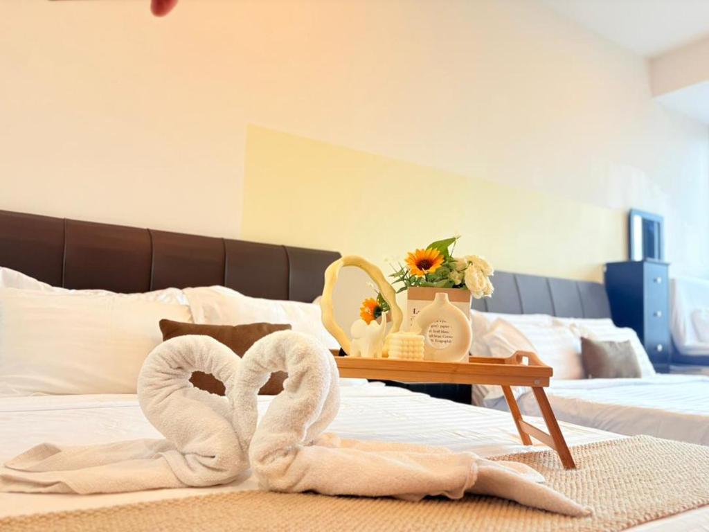 une chambre avec deux serviettes sur un lit avec une table dans l'établissement KLCC VIEW,5 mins to KL TOWER, à Kuala Lumpur