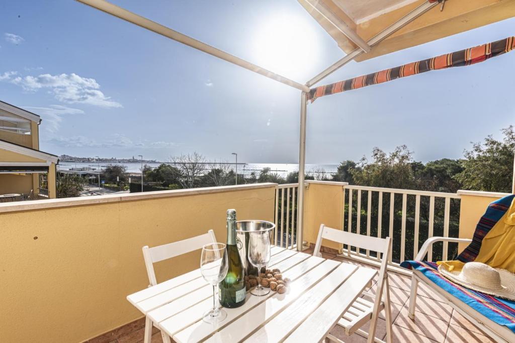 a table with two bottles of wine on a balcony at Algherocoralapartment in Alghero