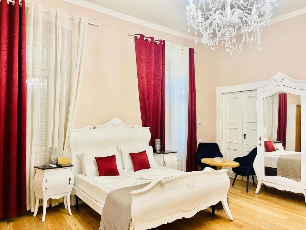 ein Schlafzimmer mit zwei weißen Betten und roten Vorhängen in der Unterkunft Beb c’est lavis in Lavis