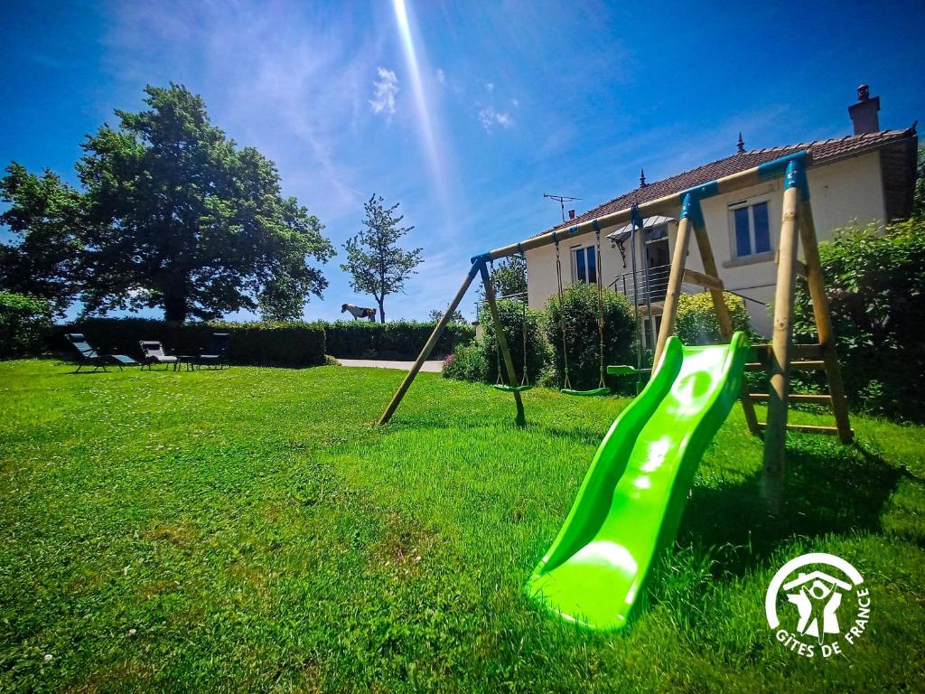 a green slide in a yard with a house at La Maison d'à côté in Taussac