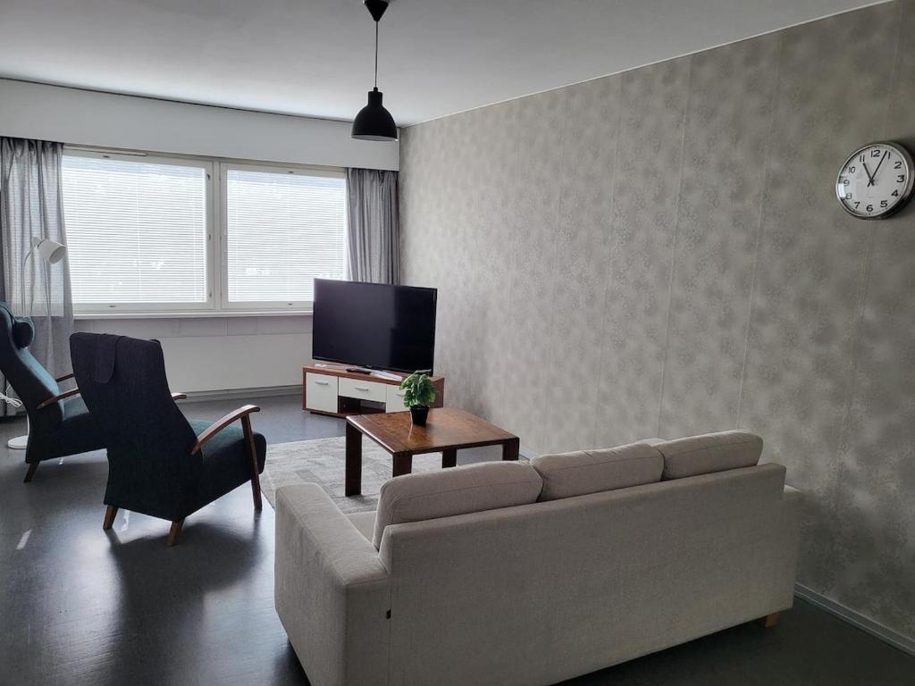 uma sala de estar com um sofá e uma TV em Kotimaailma - kolmio Kotkasta em Kotka