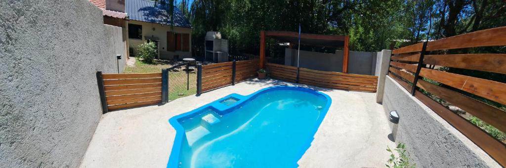 eine blaue Wanne in einem Garten neben einem Zaun in der Unterkunft Casa exclusiva con pile in San Antonio de Arredondo