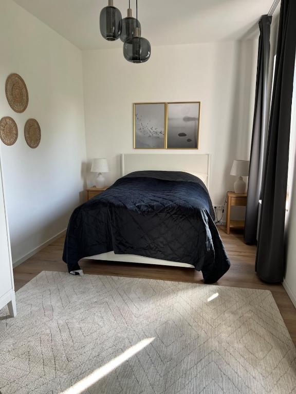 - une chambre avec un lit et une couverture noire dans l'établissement Schöne helle Wohnung, à Kerpen