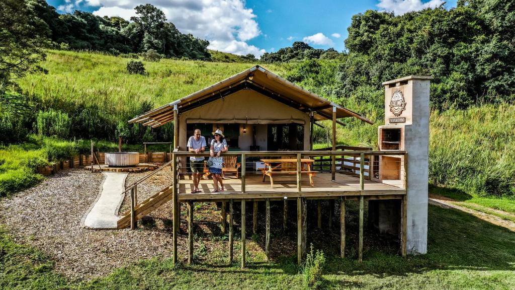 2 personnes sont debout sur une terrasse en bois dans l'établissement AfriCamps at Gowan Valley, à Balgowan