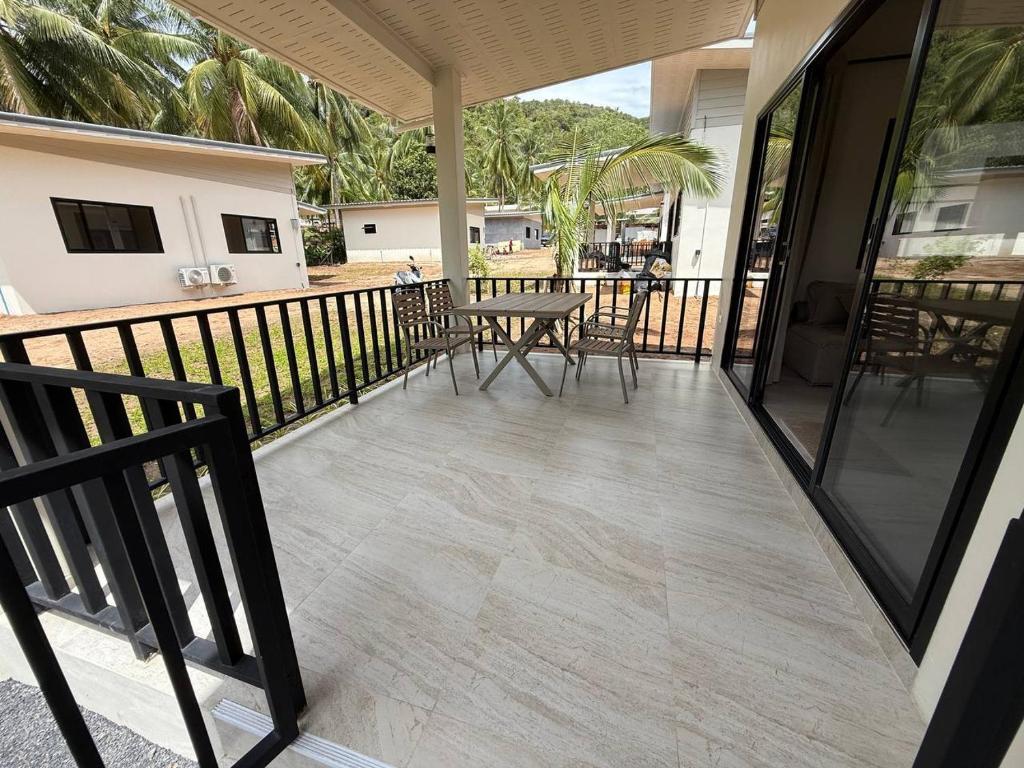 een terras met een tafel en stoelen op een balkon bij Green Horizon in Ko Pha Ngan