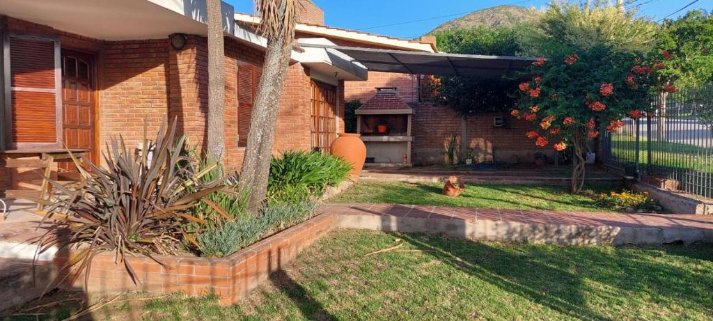 ein Haus mit einer Palme im Hof in der Unterkunft Rincon del sol in Villa Carlos Paz