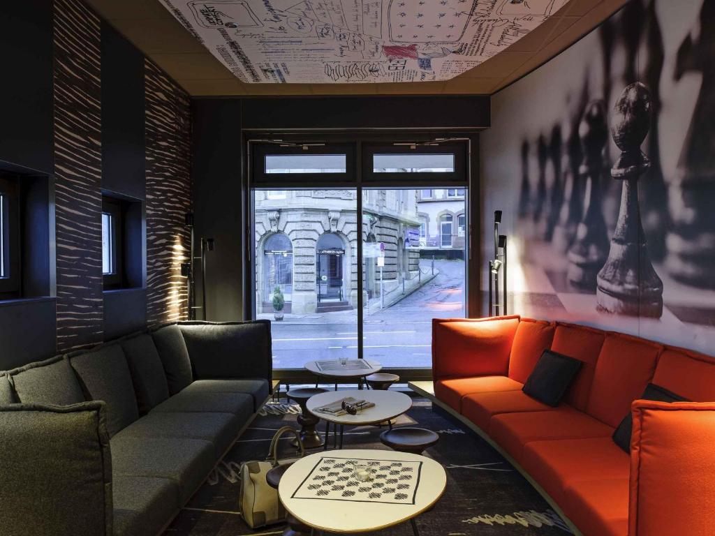 a living room with couches and tables and a window at ibis Stuttgart Centrum in Stuttgart