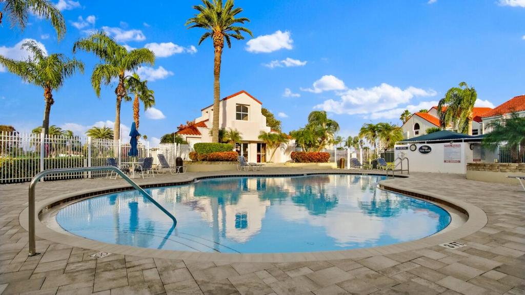 a swimming pool with palm trees and a house at St Pete Vista Verde East 3 223 Spectacular Unit in Point Brittany