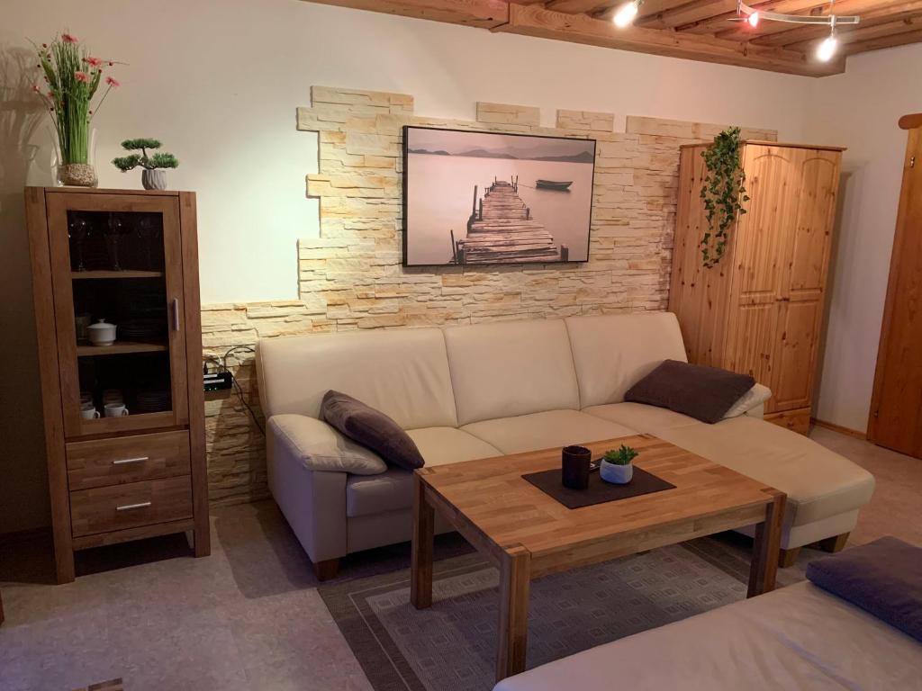 ein Wohnzimmer mit Sofa und Tisch in der Unterkunft Ferienwohnung für 4 Personen ca 50 m in Hauzenberg-Raßreuth, Bayern Bayerischer Wald in Hauzenberg