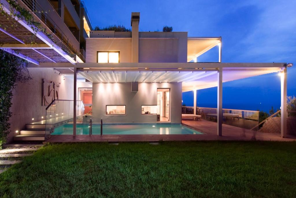 a house with a swimming pool at night at Hidden Sanctuary In Saronida in Anavissos