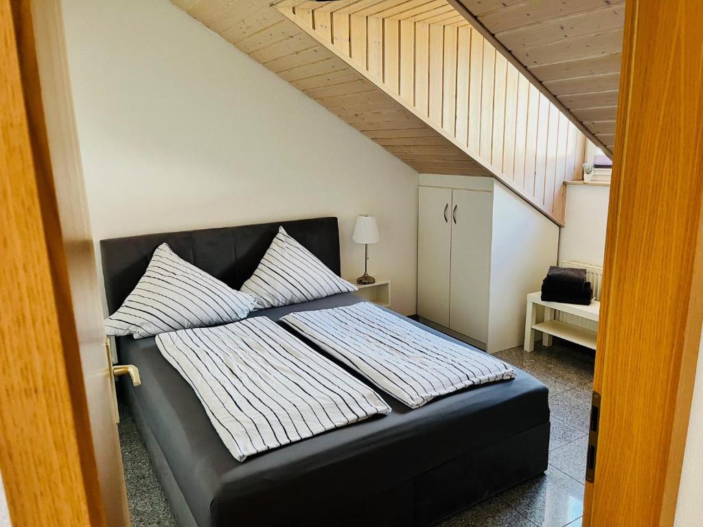 a bedroom with a black bed with white pillows at Ferienwohnung Ambiente - 3 Zimmer in Bad Säckingen