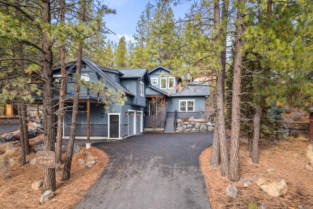 a house in the woods with a driveway at Trails End Retreat in Bend