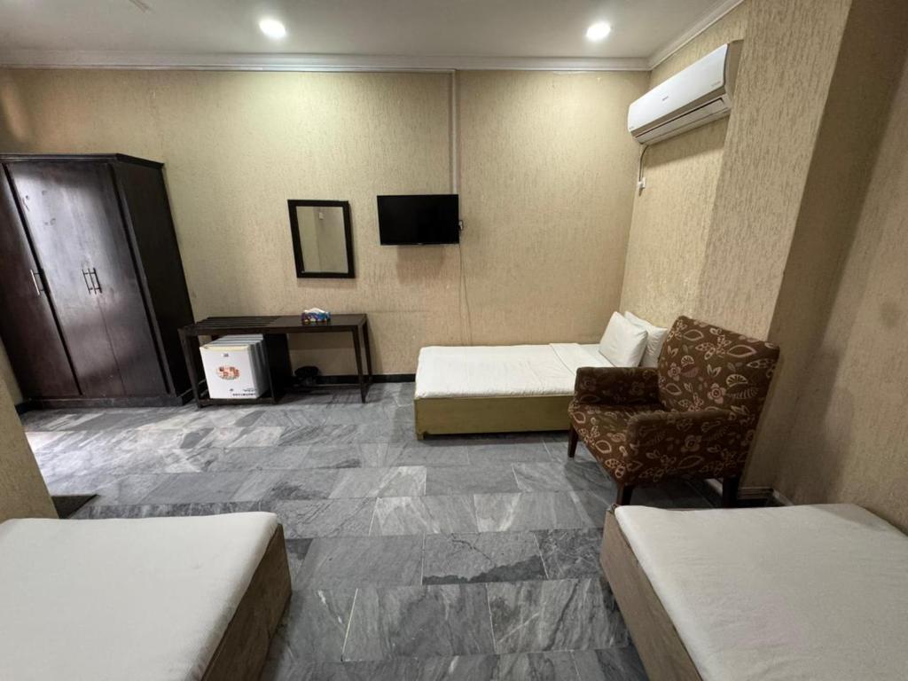 a hotel room with a couch and a chair at Crescent Hotel in Peshawar