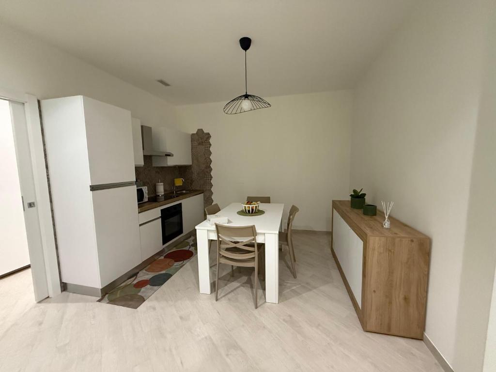 a kitchen with a white table and a table and chairs at Maison Rovaga in Ispica
