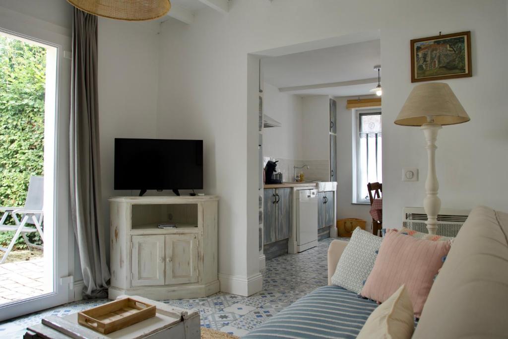 ein Wohnzimmer mit Couch und Flachbildfernseher in der Unterkunft Le Cabanon in Cosne Cours sur Loire