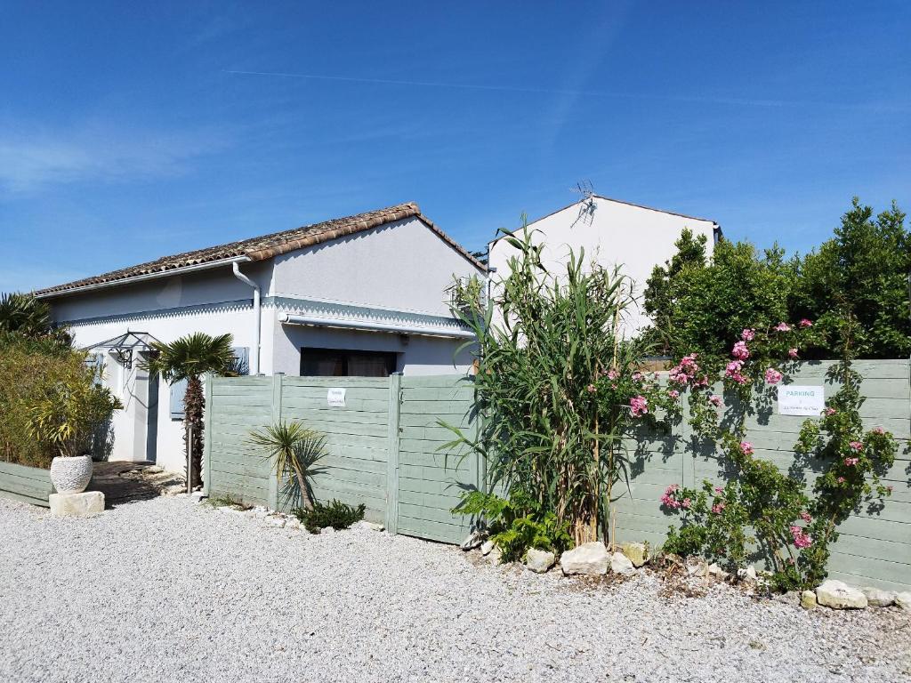 a house with a green fence and flowers at La pointe du Chay in Le Pavé