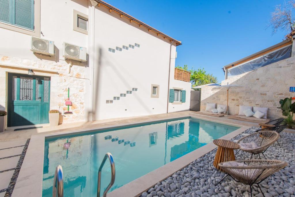 una piscina con 2 sillas junto a una casa en Villa Kirke with private swimming pool, en Próvarma