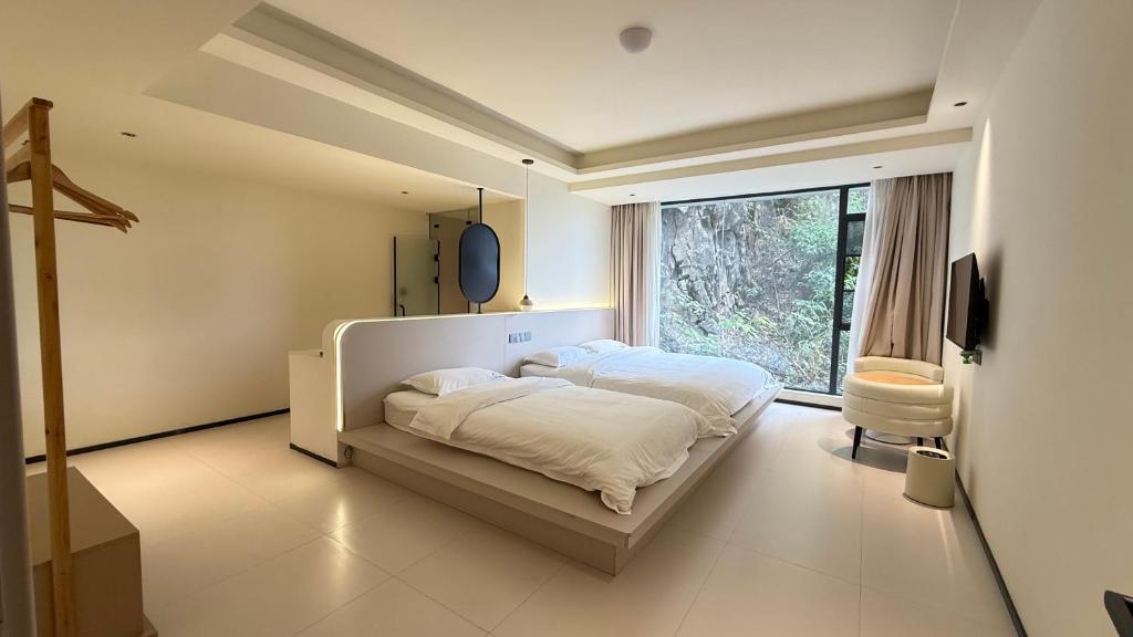 XingpingにあるBanshanyue Hotel, Yangshuoのベッドと大きな窓のある寝室