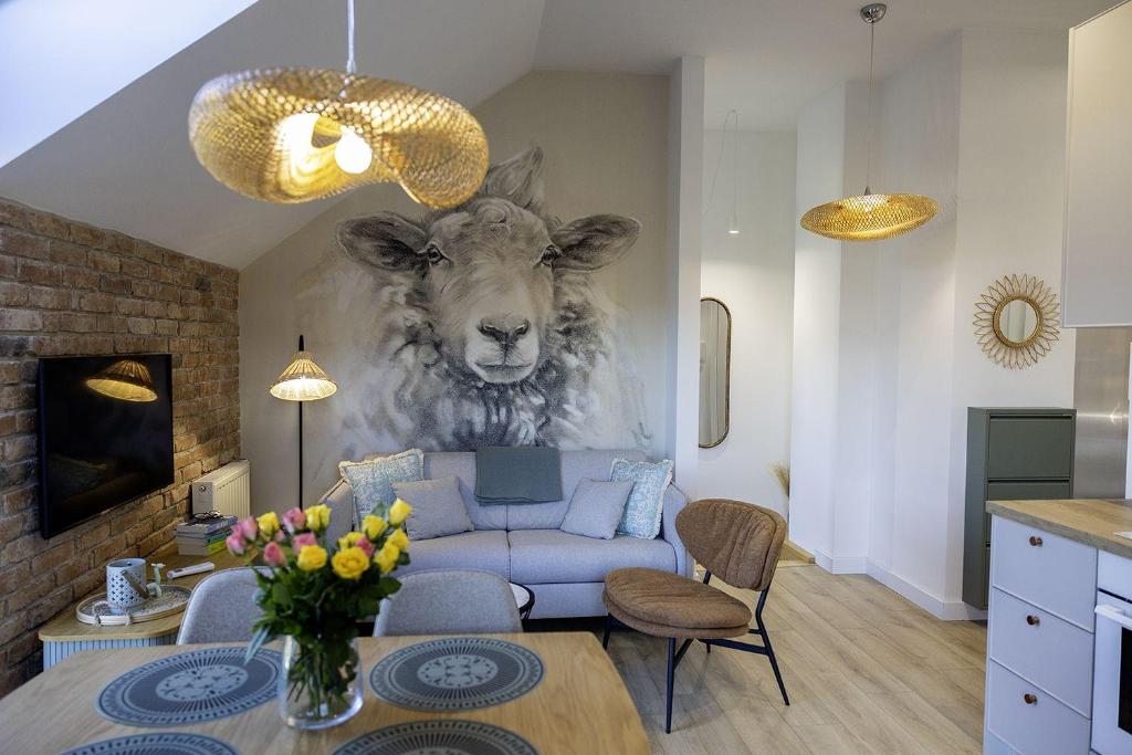 un salon avec un canapé et une peinture d'une vache dans l'établissement Apartament Na Urlop - Wisła - Magiczny Horyzont, à Wisła