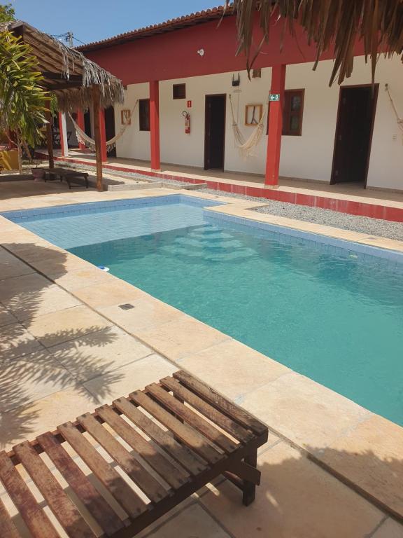 a swimming pool with a bench next to a building at Maruá Pousada da Lagoa in Jijoca de Jericoacoara